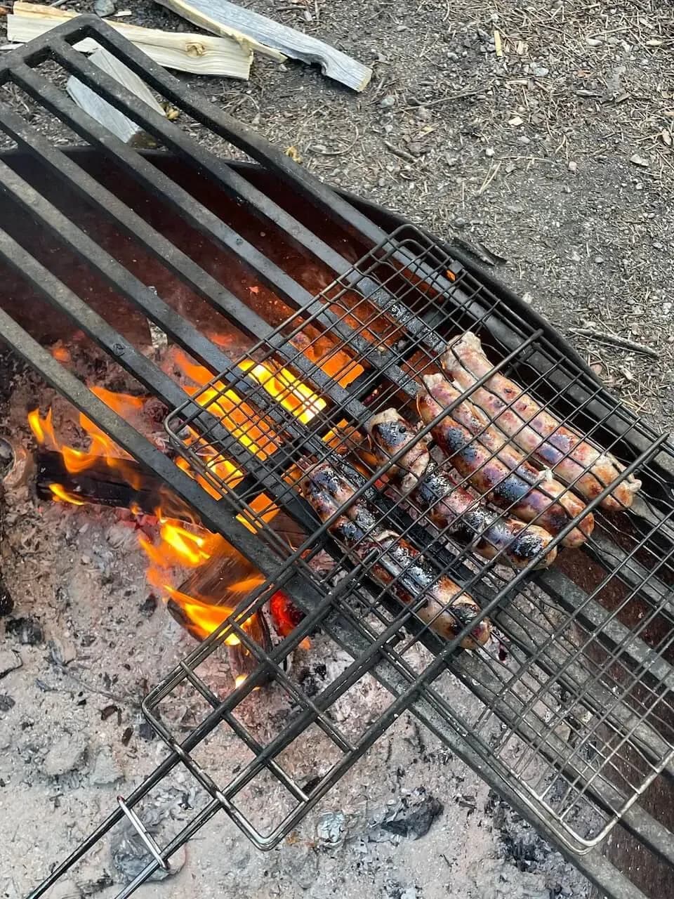 Cena che cuoce su una griglia sul fuoco da campo