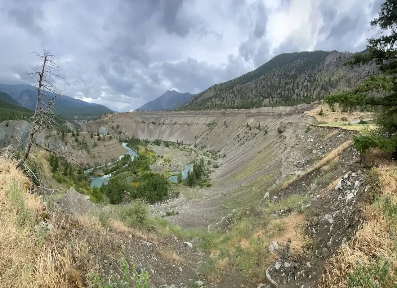 Valle arida con un fiume turchese e pendii erosi nell'interno della BC