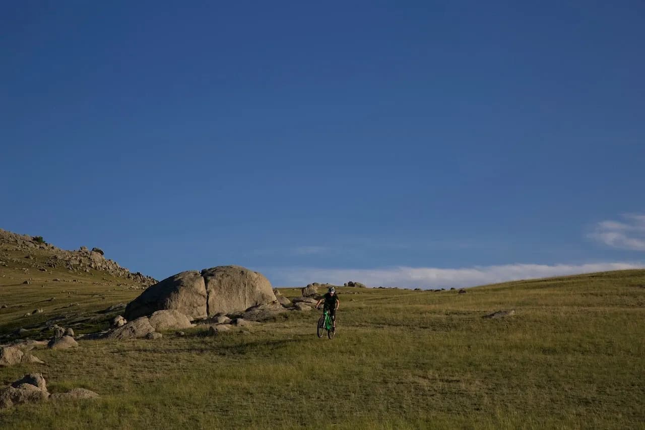Rider durchquert die offene Steppe zwischen Felsblöcken