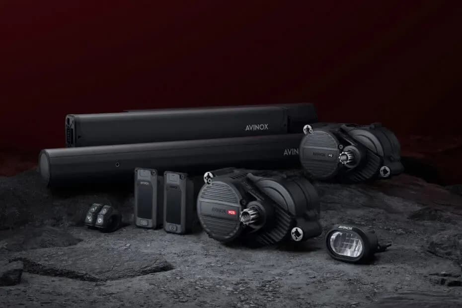 Motoren, Akkus, Displays und Fernbedienung des E-Bike-Systems DJI Avinox vor dunklem Hintergrund