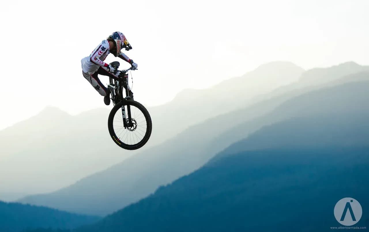 Jackson Goldstone macht mit seinem Downhill-Bike einen Whip in der Luft vor den Bergen von Whistler